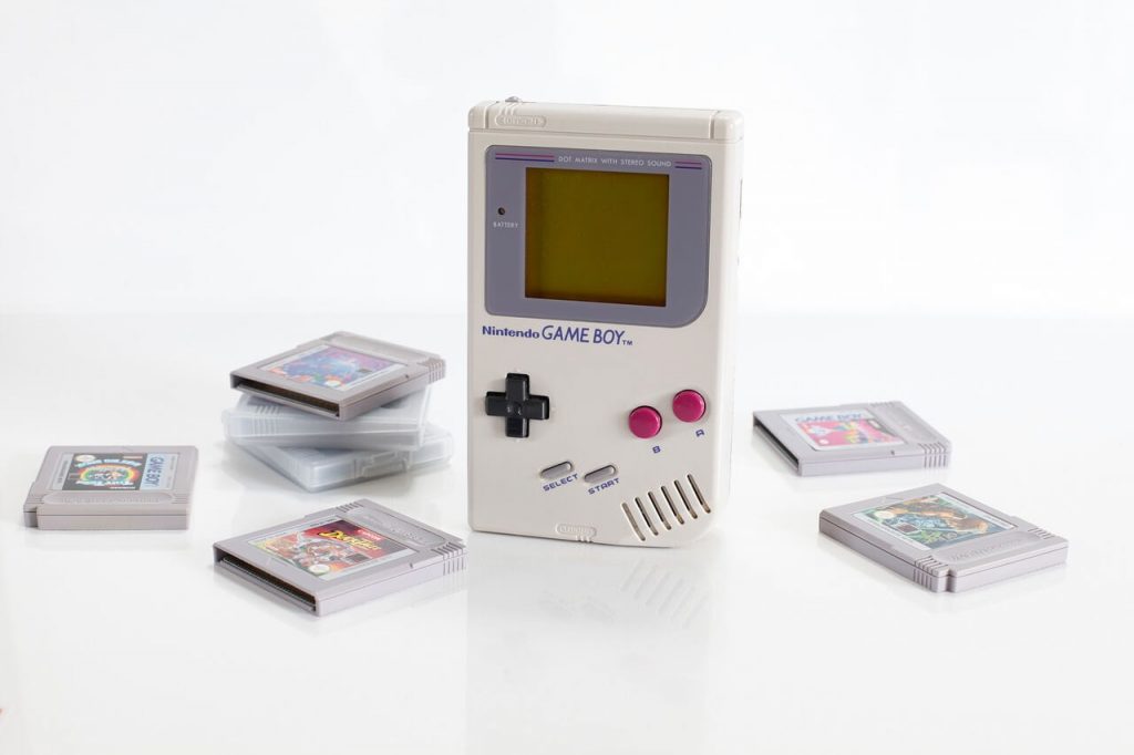 A vintage Game Boy handheld gaming console, showcasing its iconic gray design with the familiar D-pad and buttons. 
